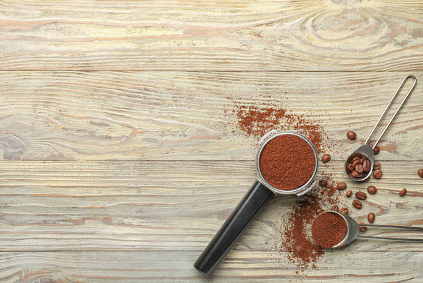 Portafilter with coffee powder and beans on wooden background - Photo, Image