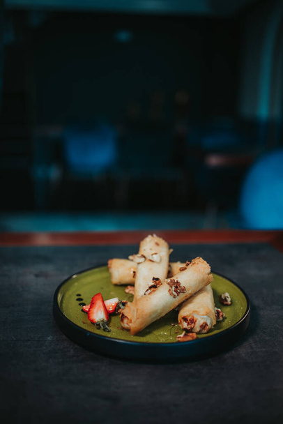 A closeup shot of delicious spring rolls in a plate on the table - Фото, изображение