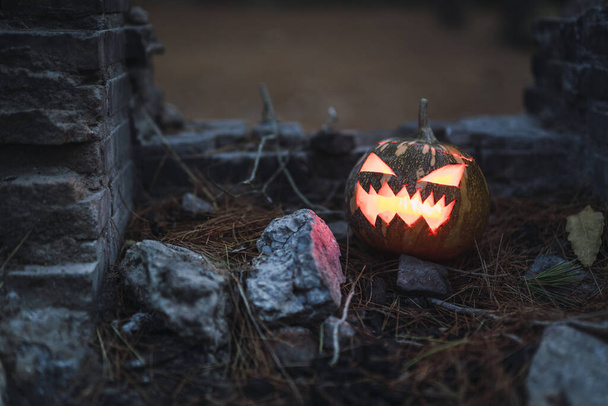 A Halloween pumpkin with a scary face on old ruins - Foto, Bild
