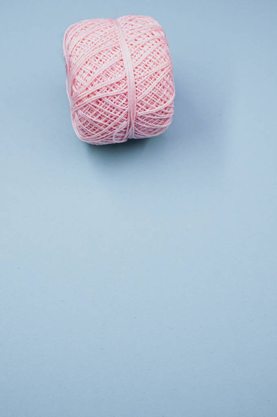 A high angle shot of a ball of yarn on a blue surface - Фото, зображення
