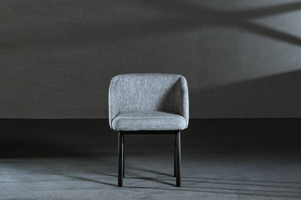 A comfy white wing chair in a studio with gray walls - Foto, Bild