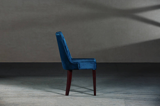 A blue dining room chair in a studio with gray walls - Foto, Bild
