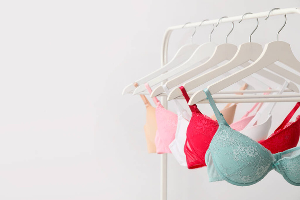 Clothes rack with stylish bras on light background - Photo, Image