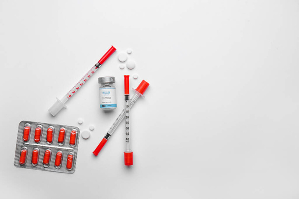 Frasco de insulina con jeringas y pastillas sobre fondo blanco. Concepto de diabetes - Foto, imagen