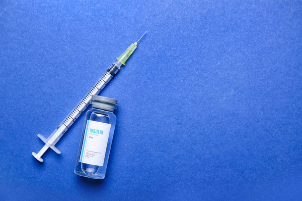 Flacone di insulina con siringa sullo sfondo del colore. Concetto di diabete - Foto, immagini