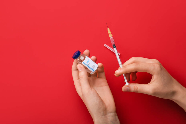 Mani femminili con flacone di insulina e siringa sullo sfondo a colori. Concetto di diabete - Foto, immagini