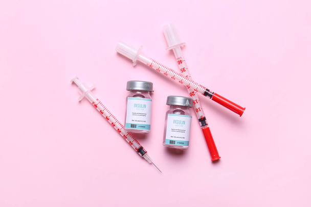 Bottles of insulin with syringes on color background. Diabetes concept - Photo, Image