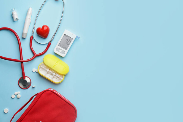 Blutzuckermessgerät mit Pillen, Stethoskop, Lanzettstift und Herz auf farbigem Hintergrund. Diabetes-Konzept - Foto, Bild