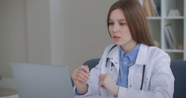 spotkanie online z doświadczonym lekarzem, kobieta komunikuje się online z pacjentem lub kolegą - Materiał filmowy, wideo