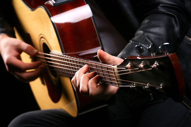 Young men playing the guitar with black background - Foto, immagini