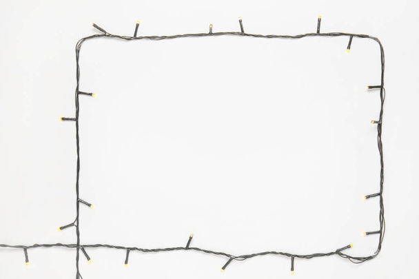 Frame made of Christmas lights on white background - Photo, Image