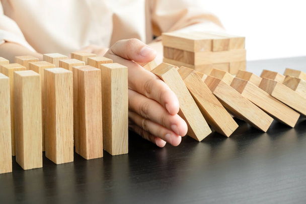 Hands of businesswoman stop block a wood game, gambling placing a wooden block. Concept Risk of management and strategy plan, protect business to success. - Фото, изображение