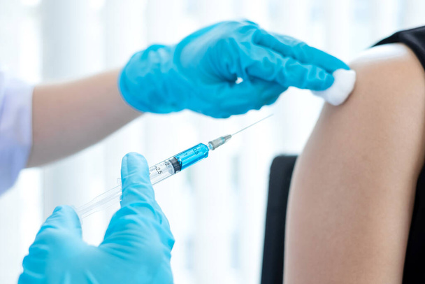 病院、医療、医療の概念で流行を防ぐために注射器でワクチンを接種した男性医師. - 写真・画像