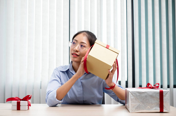 Asyalı kadın bir hediye kutusu tutuyor. Bayramlarda, Noel 'de, doğum günlerinde ya da Sevgililer Günü konseptinde sürpriz yapmaktan mutluluk duyuyor.. - Fotoğraf, Görsel