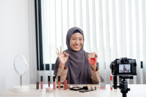 Мусульманские женщины делают видео красоты блоггеры Vlogger делать косметический макияж учебник vlog с кистями глядя камеры Сохранить клипы и поделиться ими в социальных сетях в прямом эфире через Интернет. - Фото, изображение