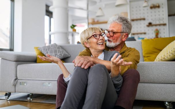 Happy senior couple hugging and enjoying retirement at home - Foto, afbeelding
