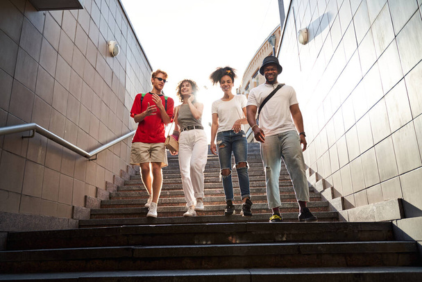 Four young people having fun together in street - Φωτογραφία, εικόνα