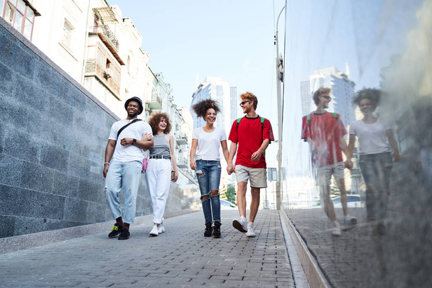 Cheerful young people walking in pedestrian subway - Foto, Imagen
