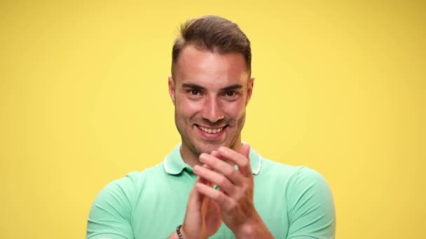young casual guy applauding, laughing, pointing at him and showing his appreciation on yellow background - Footage, Video