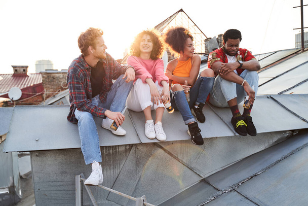 Happy friends meeting sunset on urban roof - Foto, imagen