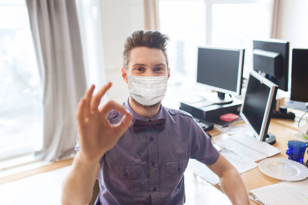 male office worker in mask showing ok sign - Φωτογραφία, εικόνα