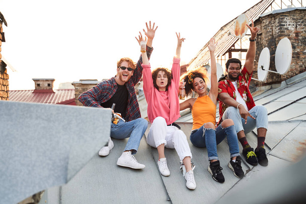 Jolly four friends having fun on roof - Photo, image