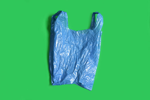 синій пластиковий мішок на зеленому фоні
 - Фото, зображення