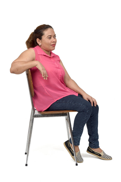 retrato de una mujer sentada en una silla con el cuerpo de perfil y aspecto lateral sobre fondo blanco, - Foto, Imagen