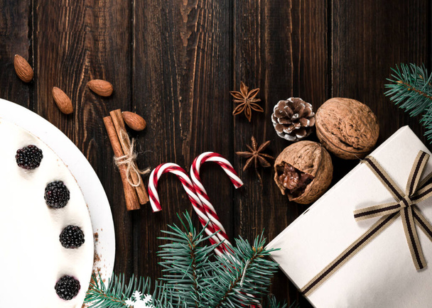 木製の背景にブラックベリーで飾られた手作りのクリスマスケーキ - 写真・画像