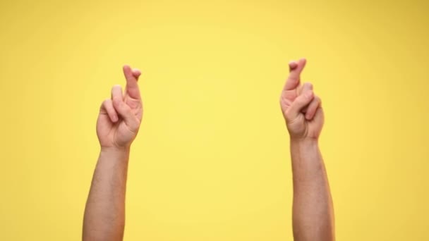 two arms crossing fingers, rotating and dancing on yellow background - Footage, Video