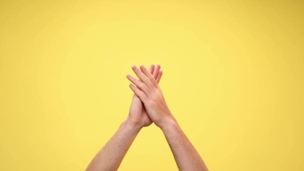 two arms are clapping, pointing at the camera and clapping again on yellow background - Footage, Video