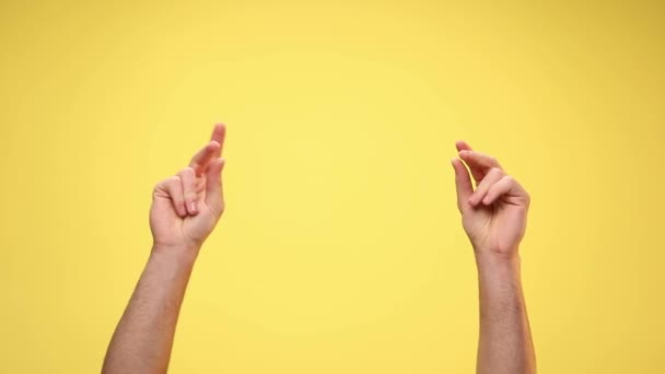 twee armen knippen vingers op gele achtergrond - Video