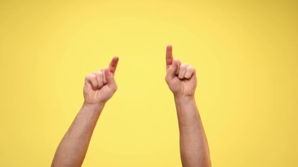 two arms pointing at the camera, giving a thumbs up and celebrating succes on yellow background - Footage, Video
