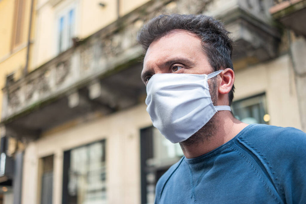 Black man wearing a white fabric mask in a city street, coronavirus covid outdoor prevention concept - Zdjęcie, obraz
