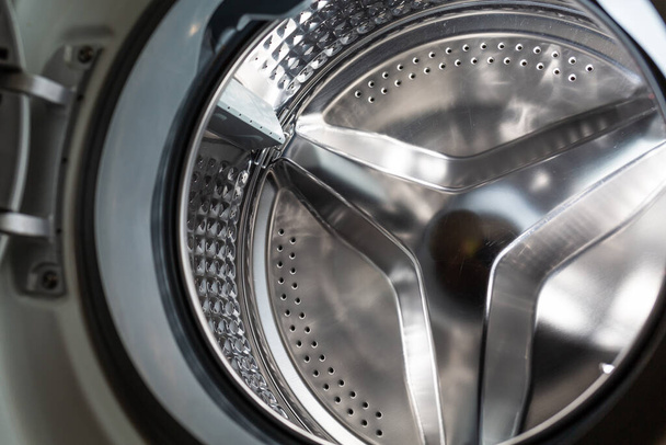 Καθαρίστε γυαλιστερό πλυντήριο μέρος του τύμπανο close-up. Η έννοια του καθαρισμού συσκευών από την κλίμακα. Άποψη από κάτω. - Φωτογραφία, εικόνα