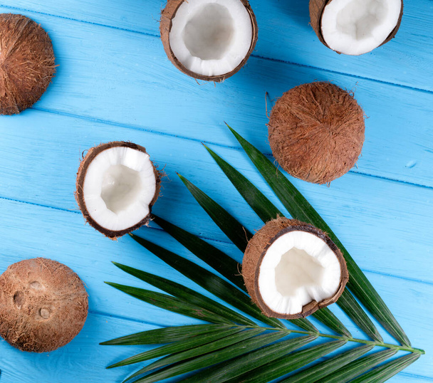 Kokosové ořechy s palmovými listy na dřevěném stole - Fotografie, Obrázek