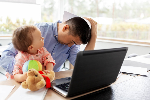 father with baby working on laptop at home office - Foto, Imagen