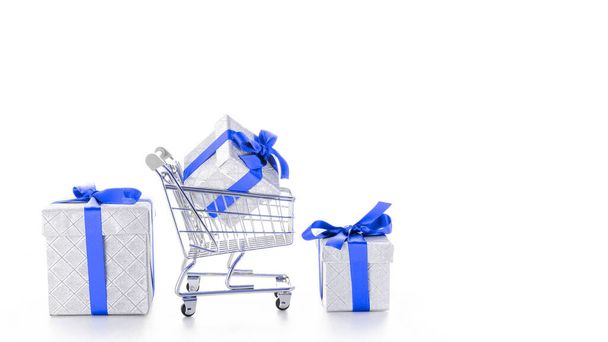 Christmas shopping. Trolley cart for supermarket with christmas or birthday gift box isolated on white background. Sale buy mall market shop consumer concept. Copy space - Photo, Image