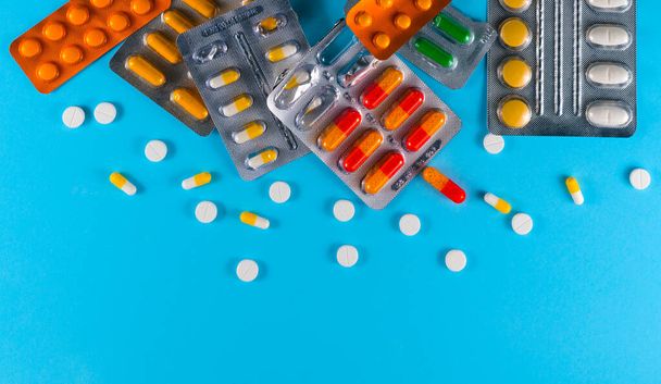 pílulas ou vitaminas em fundo azul  - Foto, Imagem