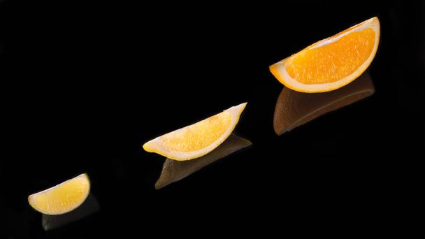 Lemon slice lime slice orange slice on a black background close up - Photo, Image