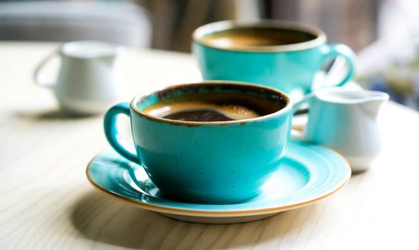 Две зеленые чашки кофе на деревянном столе - Фото, изображение