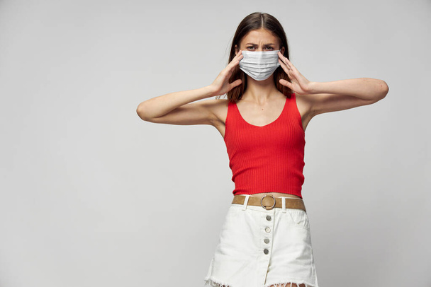 Žena v ochranné masce proti koronaviru pózující ve studiu. - Fotografie, Obrázek
