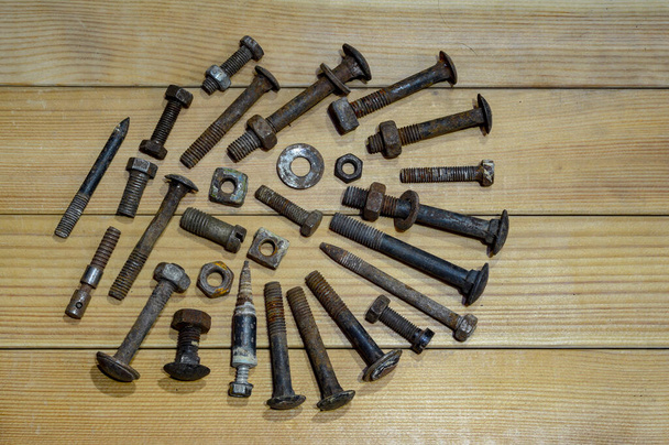 tornillos viejos, tuercas y arandelas sobre fondo de madera - Foto, Imagen
