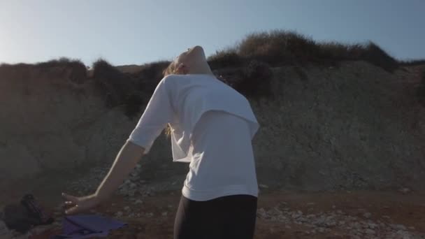 jonge sensuele vrouw oefenen yoga op het zandstrand in eraly ochtend gouden zonlicht - Video