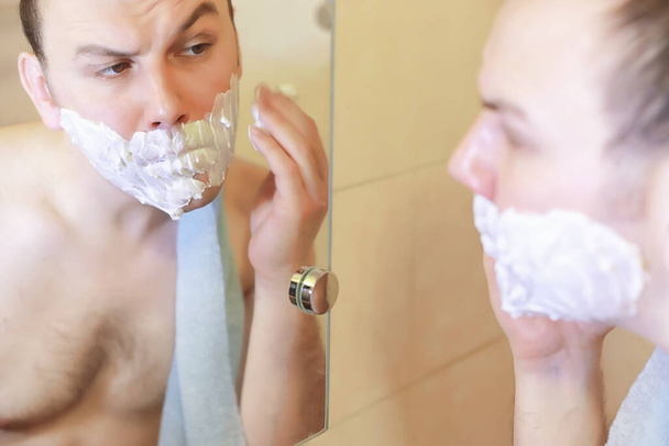 Mężczyzna goli się rano w łazience przed pracą. - Zdjęcie, obraz