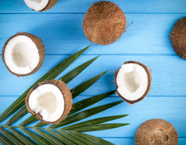 Noix de coco avec feuilles de palmier sur table en bois - Photo, image