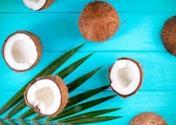 Cocos con hojas de palma sobre mesa de madera - Foto, Imagen