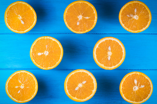 порізані апельсини на синьому дерев'яному фоні
 - Фото, зображення