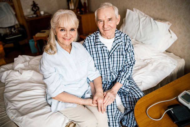 Elderly couple sitting together at bedroom - Fotoğraf, Görsel
