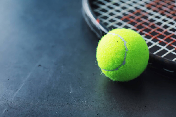 Спорт і здоровий спосіб життя. Теніс. Жовтий м'яч для тенісу і ракетка на столі. Спортивний фон з концепцією тенісу
. - Фото, зображення
